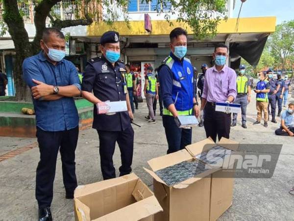 Habibi menunjukkan rokok yang berjaya dirampas dalam operasi bersepadu di Pekan Inanam, Kota Kinabalu pada Khamis.