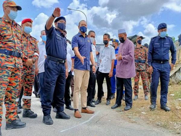 Ahmad Masrizal (tiga dari kiri) dan Ahmad Fadhli (dua dari kanan) mendengar taklimat tentang keadaan terkini tebing Sungai Kelantan runtuh yang disampaikan oleh Mohamad Roy (dua dari kiri) di Kampung Pohon Chelagi, Pasir Mas.