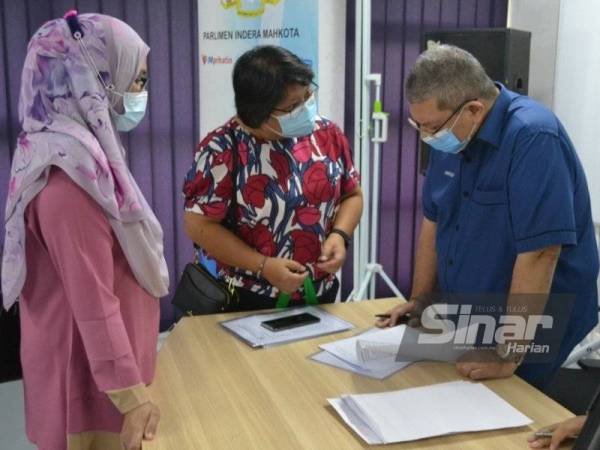 Saifuddin (kanan) bertanya sesuatu kepada guru yang hadir pada penyampaian sumbangan dana PIBG kepada 46 sekolah di kawasan Parlimen Indera Mahkota di Pejabat di Indera Mahkota, Kuantan pada Sabtu.