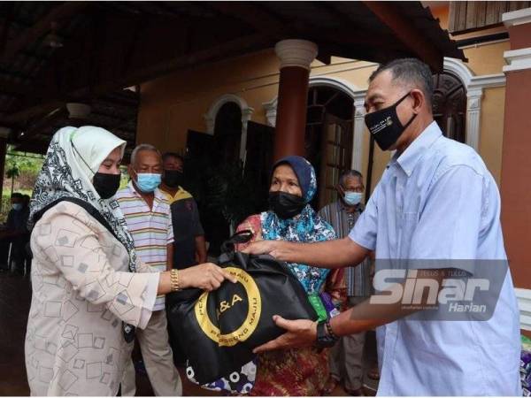 Rosol (kanan) menyampaikan bantuan khas barangan makanan kepada penduduk terjejas Covid-19 di Pusat Khidmat Ahli Parlimen Hulu Terengganu, Kuala Berang pada Ahad.