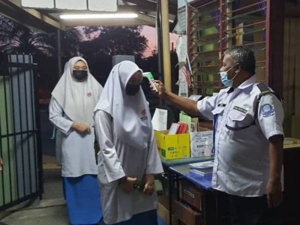 Calon SPM di SM Taman Semarak, Nilai mengimbas suhu sebelum dibenarkan masuk ke sekolah bagi menduduki peperiksaan SPM pada Isnin.