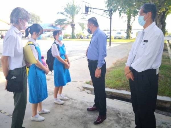 Muslimin (dua dari kanan) beramah mesra bersama calon SPM di SMJKC Yoke Kuan, Sekinchan pada Isnin.