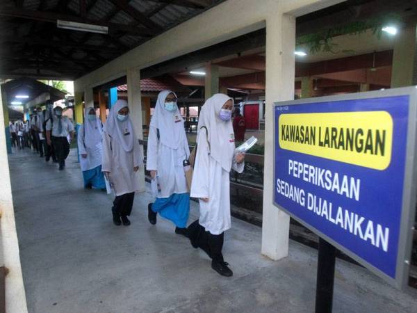 Calon-calon Sijil Pelajaran Malaysia (SPM) 2020 bergerak menuju ke dewan peperiksaan ketika tinjauan di sekolah sekitar Putrajaya hari ini. Foto Bernama