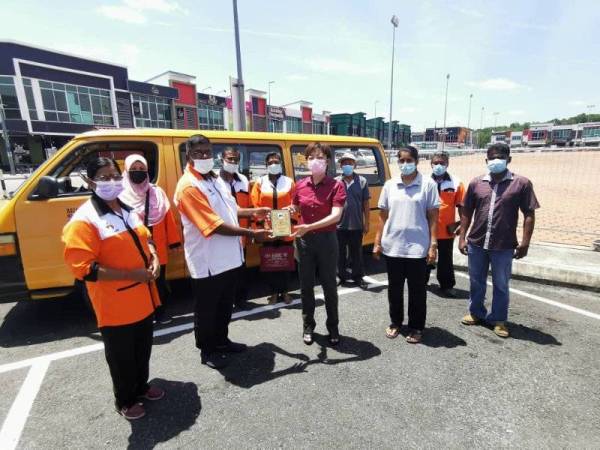 Nicole (tengah) menyampaikan sumbangan kepada Persatuan Pengusaha-Pengusaha Bas Sekolah Seremban di Seremban pada Ahad.