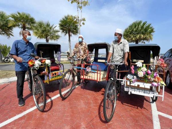 Pengayuh beca Mohd Nor Mamat, 65, (kanan), Abdul Wahab Abdul Rahman, 76, dan Asmad Mohamad, 73, berbincang sesuatu sesama mereka mengenai masa depan mereka ketika ditemui di Pasar Besar Kedai Payang pada Selasa. - Foto Bernama