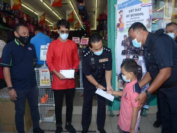 Razali (tiga dari kiri) ketika Program Penyampaian Baucar Sekolah kepada anak-anak anggota IPD Serdang di Pusat Pakaian Hari Hari di Taman Sri Serdang pada Jumaat.