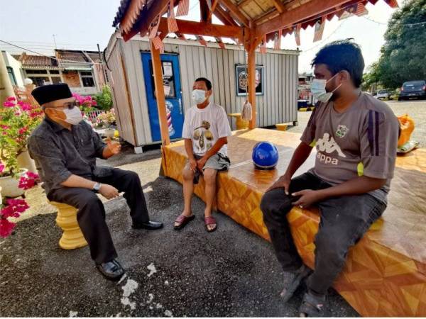 Zulkifli (kiri) berbual dengan Muhammad Ibraheem (kanan) dan Kar Foo selepas menerima bantuan daripada PCRS di Seremban, Negeri Sembilan pada Ahad.