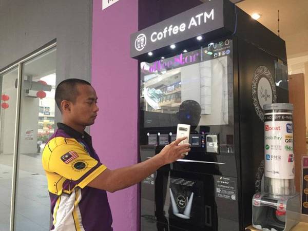 Raja Ahmad Fauzan menunjukkan cara menggunakan Coffee ATM.