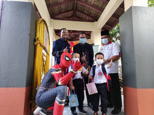 Pasangan kembar, Adam Fitri dan Adam Fikri teruja dapat bergambar dengan Spiderman pada hari pertama mereka ke sekolah.