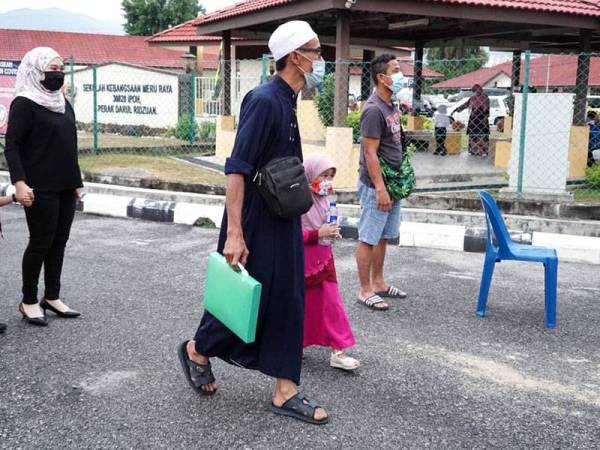 Mohd Firdaus menghantar Wafa Afifah ke SK Meru Raya pada hari pertama pembukaan semula sesi persekolahan pada Isnin.