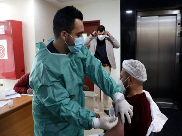 Gambar fail menunjukkan seorang pekerja kesihatan Palestin Palestinian menerima suntikan vaksin Covid-19 di sebuah hospital di Nablus, Tebing Barat. - Foto AFP