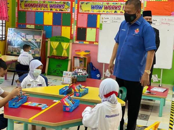 Che Zakaria (kanan) meninjau hari pertama sesi pembukaan persekolahan di Sekolah Kebangsaan (SK) Taman Bukit Dahlia, Pasir Gudang, pada Isnin.