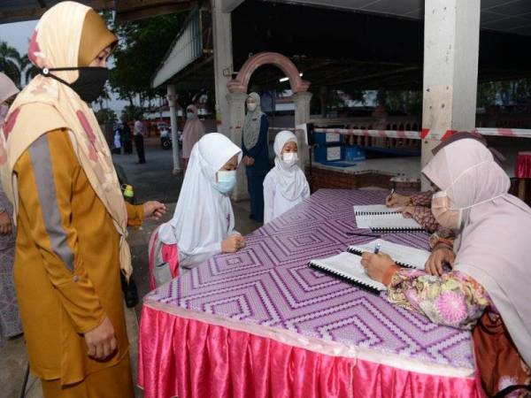 Guru SK Haji Mohd Shariff memastikan murid mematuhi SOP ketika berada dalam kawasan sekolah pada hari pertama sesi persekolahan.