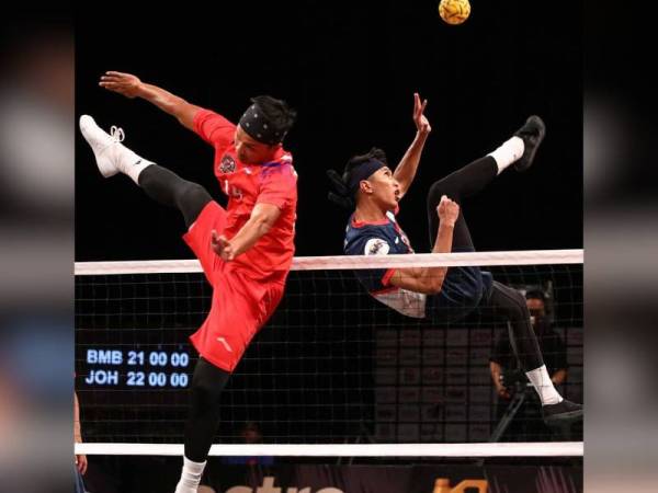 Pemain Johor Tigris, Muhammad Noraizat Mohd Nordin melakukan libasan sambil cuba dihalang pemain Bomba Fighters, Nasyrul Izuan Tolos. - Foto FB Sepak Takraw League