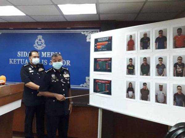 Ayob Khan menunjukkan gambar suspek yang terlibat dengan sindiket penipuan dalam talian pada sidang akhbar di IPK Johor, Johor Bahru, Khamis.