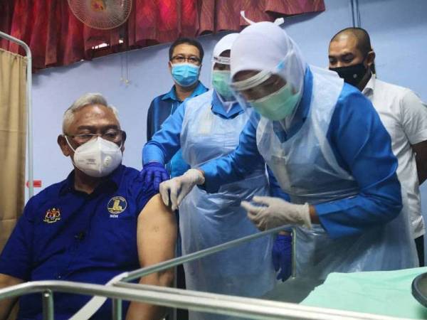 Noh (kiri) menerima suntikan vaksin Covid-19 di Hospital Tanjong Karang, Selangor pada Khamis.