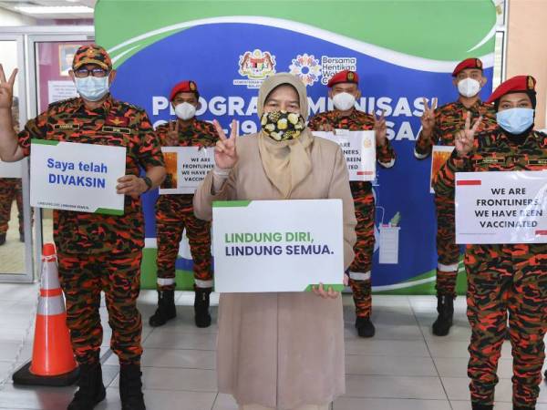 Zuraida bersama Mohammad Hamdan (kiri) dan pegawai bomba selepas menerima suntikan vaksin Covid-19 jenis Pfizer BioNTech di Klinik Kesihatan Putrajaya, Presint 18 hari ini. - Foto Bernama