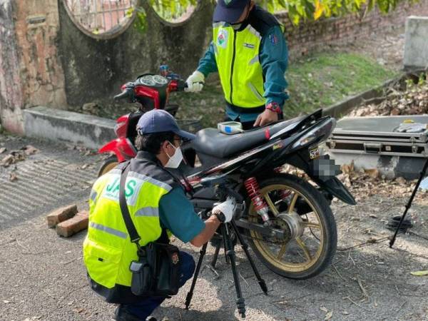 Pegawai JAS yang terlibat dalam Ops Khas Kesalahan Bunyi Bising menggunakan alat untuk mengukur kadar bunyi yang dikeluarkan sebuah motosikal yang didapati mengubah suai ekzos.