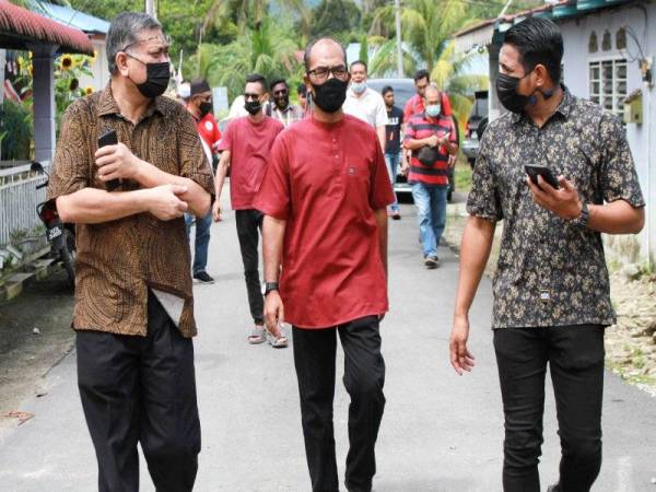 Shamsul Anuar (kiri) selepas menyampaikan sumbangan barangan keperluan asas kepada penduduk Kampung Kelantan pada program Sayangi Lenggong di kampung tersebut hari ini. Foto Bernama