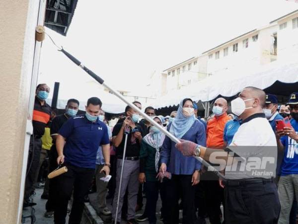 Saarani (kanan) mengecat dinding sebagai simbolik merasmikan program Gotong-Royong Bersama Menteri Besar Perak di Rumah Pangsa Conolly, Ipoh pada Ahad.