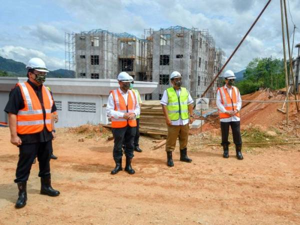 Mustapa (dua, kiri) bersama Mohd Zuki (kiri) ketika hadir melawat tapak Projek Rumah Keluarga Angkatan Tentera (RKAT) di Kem Sungai Tumbi hari ini. -Foto Bernama