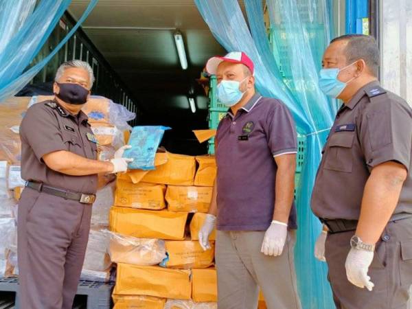 Saiful Yazan (kiri) memeriksa ayam beku yang akan diserahkan kepada Zoo Negara di Pejabat Maqis Rantau Panjang.