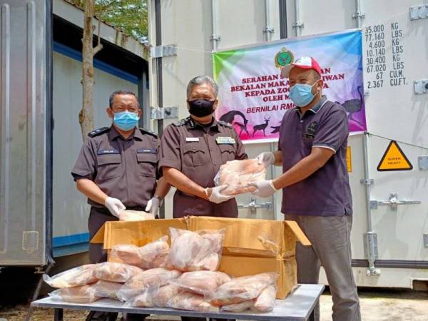 Saiful Yazan (tengah) bersama Roslan (kiri) menyerahkan ayam beku kepada Zoo Negara yang diwakili oleh, Dr Naim (kanan) di Pejabat Maqis Rantau Panjang.