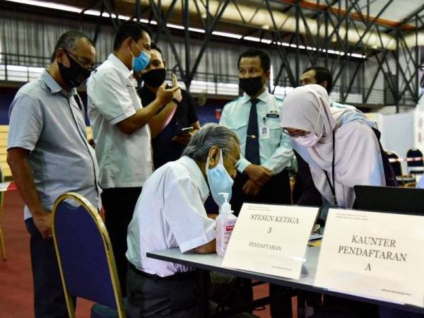 Dr Mahathir diperiksa petugas kesihatan sebelum diberikan suntikan vaksin Covid-19 di Langkawi pada Ahad.