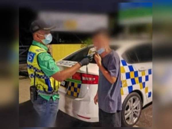 Polis menjalankan ujian saringan pernafasan kepada salah seorang pemandu yang ditahan dalam Op Mabuk sekitar Ipoh, Taiping dan Manjung. - Foto Ihsan PDRM