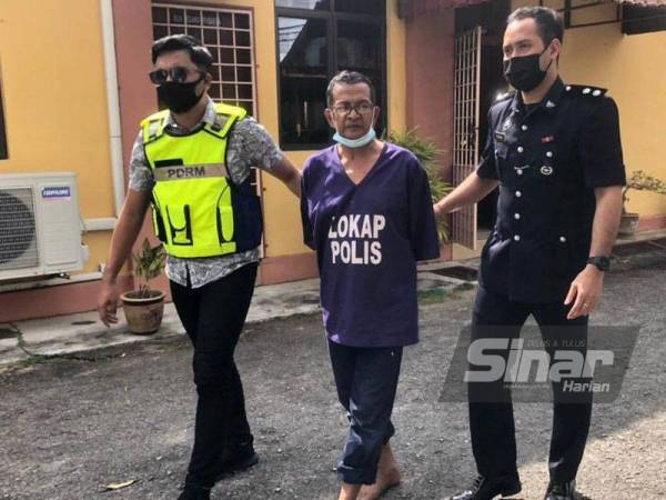 Tertuduh (tengah) diiringi dan dikawal ketat pegawai polis dari Jabatan Siasatan Jenayah Komersial (JSJK) Kelantan ketika keluar dari lokap Mahkamah Majistret Tumpat pada Isnin.