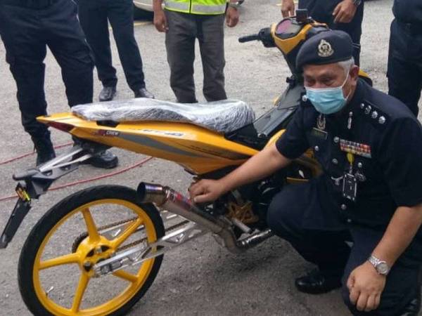 Zulkefly (duduk) menunjukkan sebuah motosikal yang diubah suai pada sidang akhbar di JSPT Kuala Lumpur, Jalan Tun HS Lee di Kuala Lumpur pada Isnin.