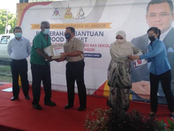 Amirudin (tiga dari kiri) menyampaikan sumbangan bakul makanan kepada salah seorang penerima dalam program berkenaan yang berlangsung di Dewan Terbuka Kampung Melayu Batu Caves, Gombak pada Selasa.