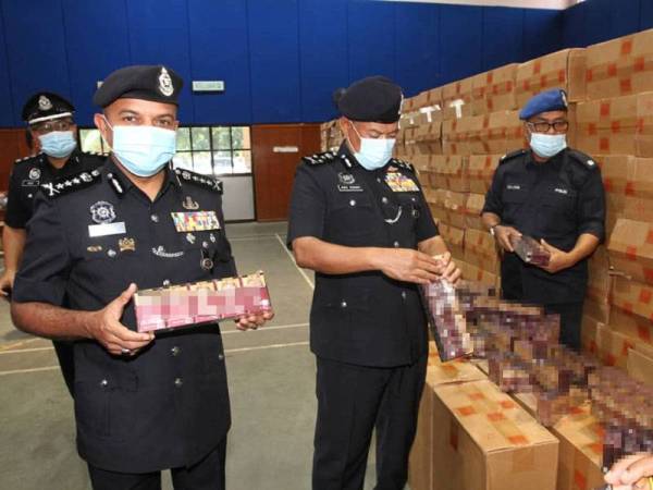 Abd Rahim (dua dari kanan) dan Ayob Khan (kiri) menunjukkan pelbagai jenis rokok yang dirampas selepas menahan sebuah kapal asing di Pulau Kukup, pada sidang akhbar di IPD Pontian, pada Rabu.