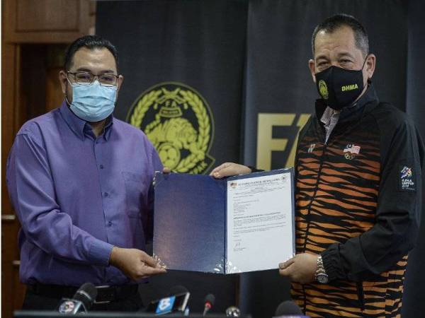 Hamidin (kanan) menerima dokumen pelantikan sebagai Ketua Kontinjen Malaysia ke Sukan SEA 2021 daripada Norhashimi di Wisma FAM pada Rabu. FOTO: BERNAMA