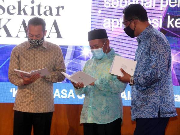 Tuan Ibrahim (tengah) melihat buku 'Seratus Antologi Puisi Alam Sekitar Kementerian Alam Sekitar dan Air (KASA)' pada Majlis Sambutan Ulang Tahun Pertama KASA hari ini. - Foto Bernama