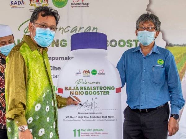 Che Abdullah ( kiri) ketika perasmian pelancaran Baja Realstrong N Bio Booster di Bendang Lipan, Mukim Lalang hari pada Khamis. 