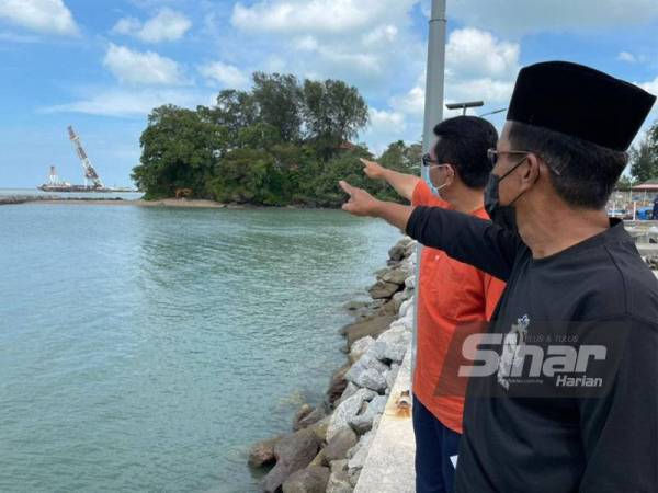 Aziz dan Khairulazni menunjukkan jentera yang digunakan untuk menjalankan kerja-kerja cerucuk bagi pembinaan jeti pelabuhan.