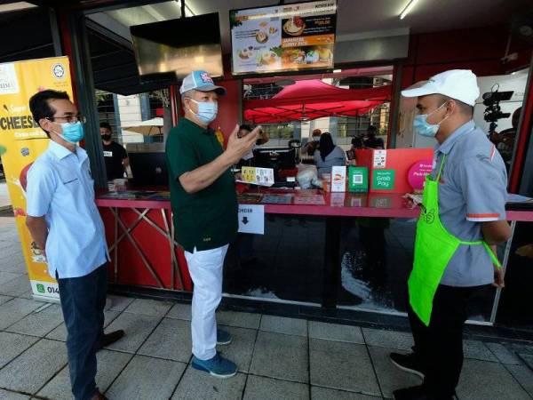 Annuar (tengah) beramah mesra bersama pemilik kiosk Cheese U Kharul Azman A Karim (kanan) semasa program tinjauan mesra ke Kiosk Usahawan Muda Kota dan Anjung Floria Putrajaya, hari ini. - Foto Bernama