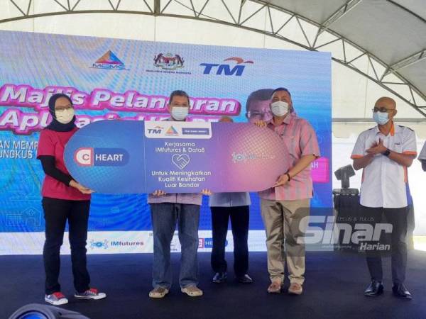 Saifuddin (tengah) melancarkan Aplikasi C-Heart dan memperkenalkan Perkhidmatan Bungkus dan Hantar di Pusat Internet Komuniti Kampung Cherating, pada Ahad.