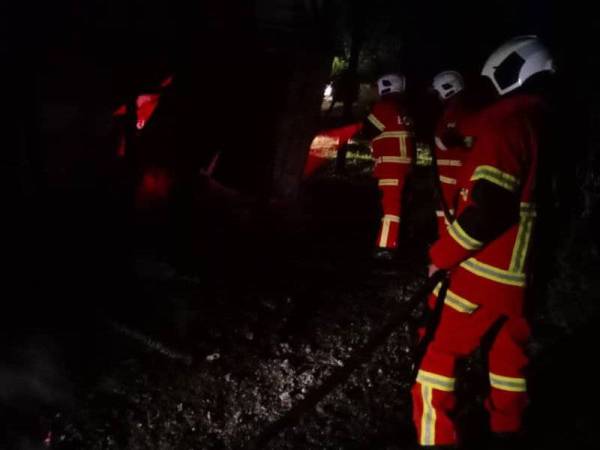 Pasukan bomba berusaha memadamkan kebakaran rumah di Kampung Tombongon, Kiulu, Tuaran.