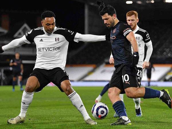 Aguero (kanan), cuba melepasi pertahanan Fulham.