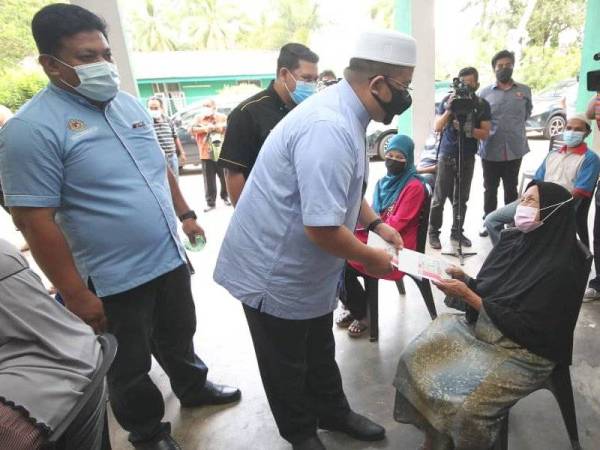 Ahmad Marzuk menyampaikan sumbangan wang tunai kepada salah seorang penerima pada Isnin.