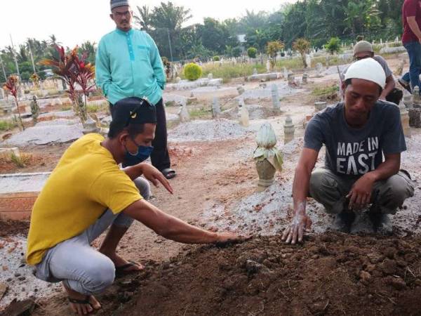 Muhammad Azuaan Bakri, 35, (kanan) ketika pengebumian Muhammad Firdaus di Tanah Perkuburan Islam Kampung Sungai Sireh, petang Selasa.