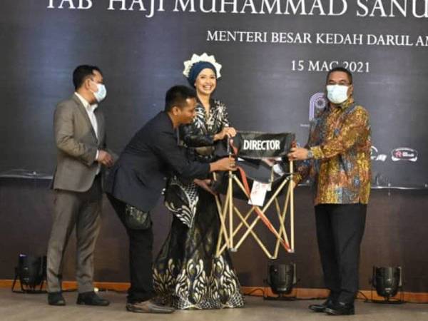 Muhammad Sanusi (kanan) menerima kerusi ‘director’ sebagai simbolik pelancaran 'The Puppet Master Trilogy' di Dewan Seri Mentaloon pada Isnin malam.