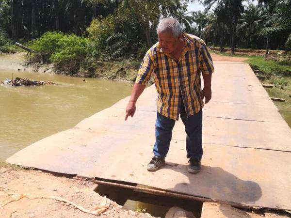 Mohamad Tuhid menunjukkan lantai jambatan besi di Jalan Abd Aziz yang semakin lekang dan mereput hingga mengundang bahaya kepada pengguna. 