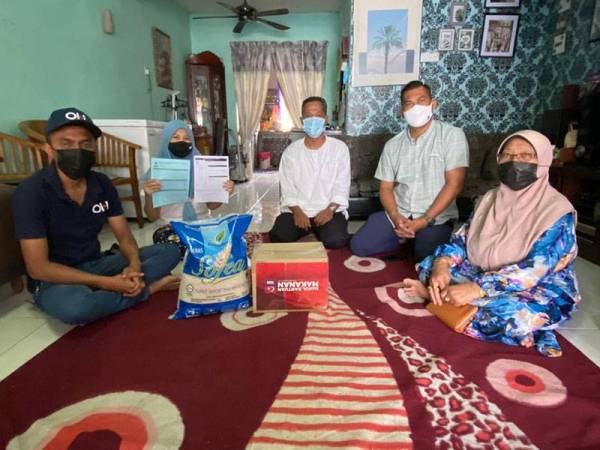 Mohd Hafiz Shukor (kiri) menemui Shahril (tengah) dan isterinya, Normaliz (dua dari kiri) di kediamannya di Taman Renggam Jaya, Simpang Renggam, Kluang, pada Selasa.