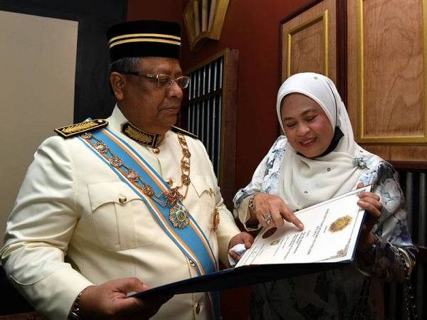 Zainal Rahim menunjukkan anugerah Darjah Utama Pangkuan Negeri (DUPN) yang membawa gelaran Datuk Seri Utama kepada Puan Sri Datuk Nik Hasmah Nik Kadir selepas istiadat Penganugerahan Darjah Kebesaran, Bintang dan Pingat Kehormat Negeri Pulau Pinang 2020 daripada Yang Dipertua Negeri Tun Abdul Rahman Abbas di Setia Spice Convention Centre, Georgetown pada Rabu. - Foto Bernama