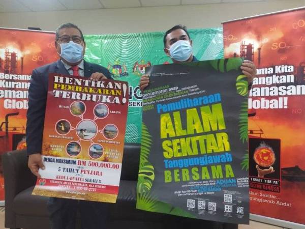 Ghafaar (kiri) dan Rosli menujukkan gegantung kempen kesedaran pencegahan pembakaran terbuka selepas sidang akhbar di Menara Persekutuan, MiTC, Ayer Keroh, di sini, pada Rabu.