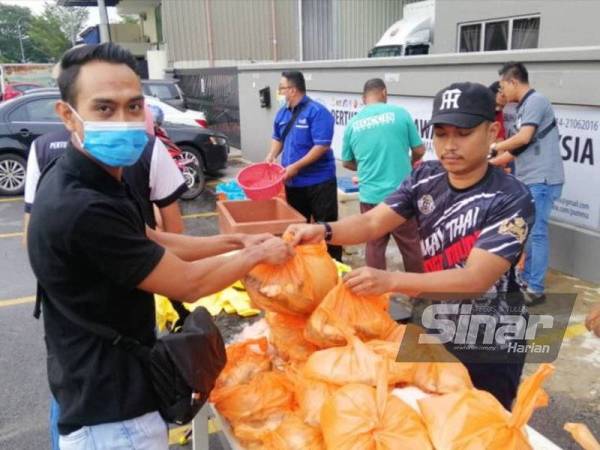 Jawatankuasa penganjur mengagihkan ikan kembung percuma kepada penerima di pekarangan Pejabat PUMMA, Wisma Chasemen, Taman Tasik Tambahan, Ampang pada Rabu.