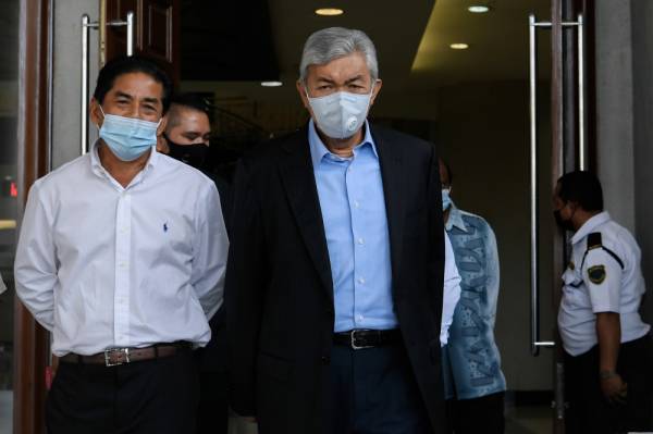 Ahmad Zahid (dua, kiri) meninggalkan Mahkamah Tinggi selepas perbicaraan kesnya hari ini. -Foto Bernama